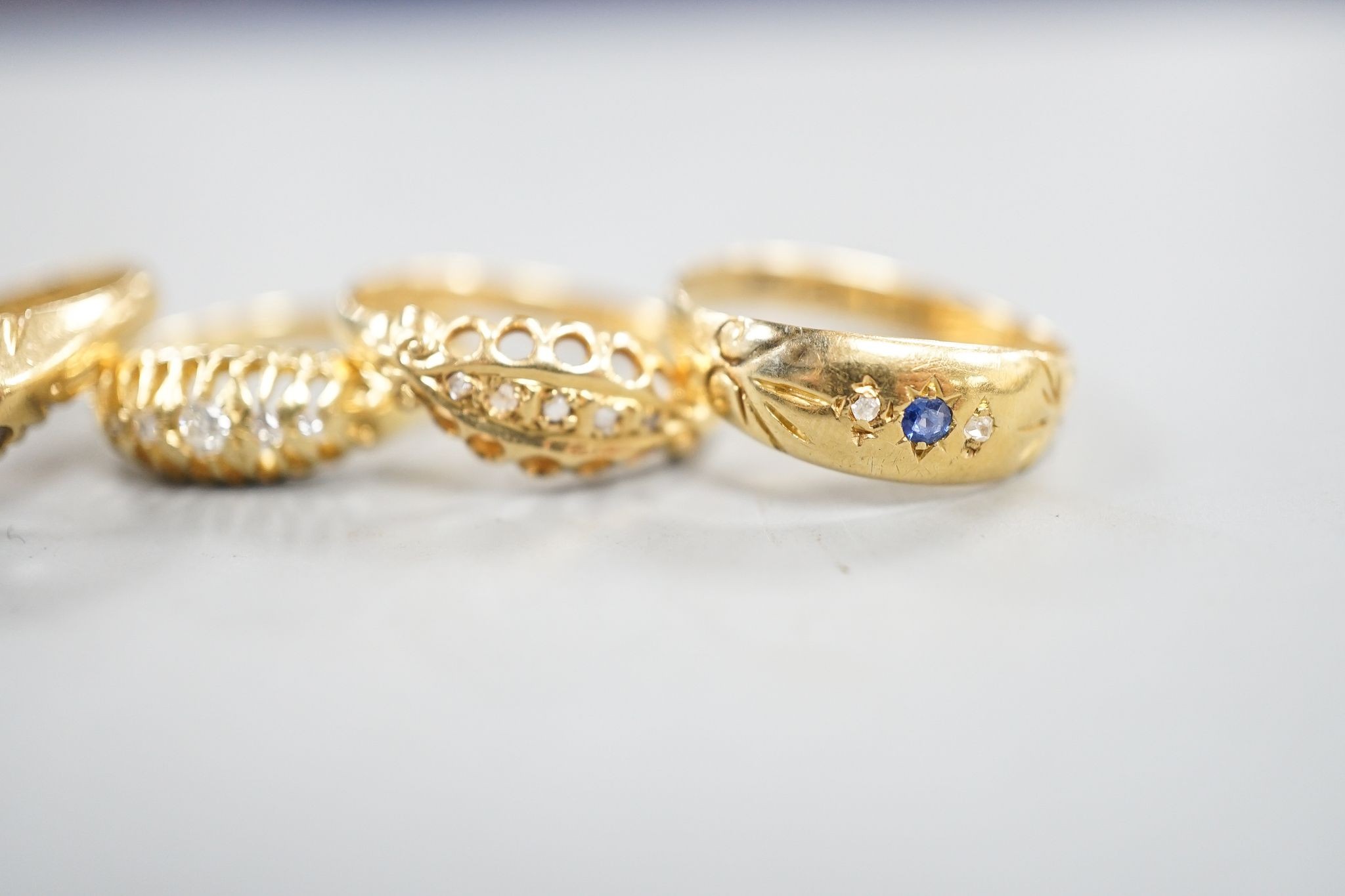 Three early 20th century 18ct gold and five stone diamond chip set rings, an 18ct , sapphire and diamond chip set ring and a late Victorian 18ct gold and solitaire diamond ring, gross weight 12.1 grams.